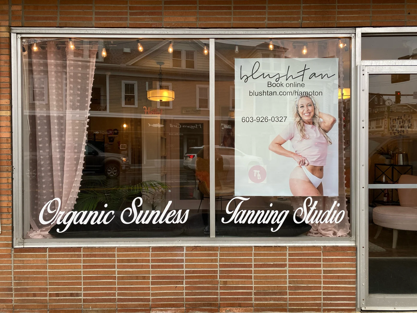 White Organic Sunless Tanning Studio script lettering across the BlushTan storefront windows.